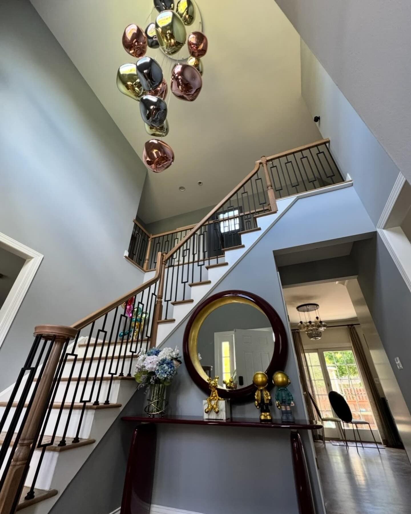 A cluster of mirrored glass globe pendants hanging down a two-story stairwell
