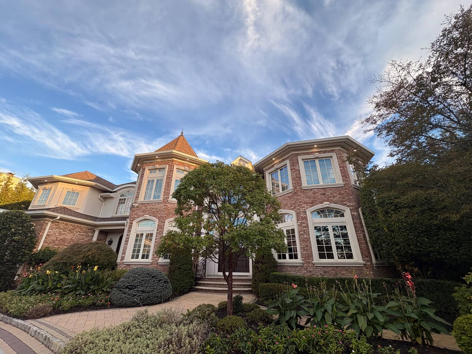 A large brick house in Livingston with arched windows and soffit and exterior lights, a Copper Electric job